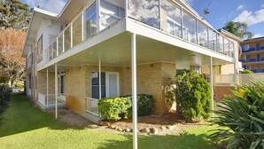 A two-story house with a covered porch and a small garden area. - Beachside Shoal Bay Unit 4 (Shoal Bay)