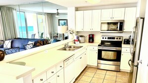 Una cocina moderna con armarios blancos, horno de acero inoxidable y microondas.
