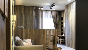 Ein modernes Wohnzimmer mit einer Couch, einem kleinen runden Tisch und einer Lampe.