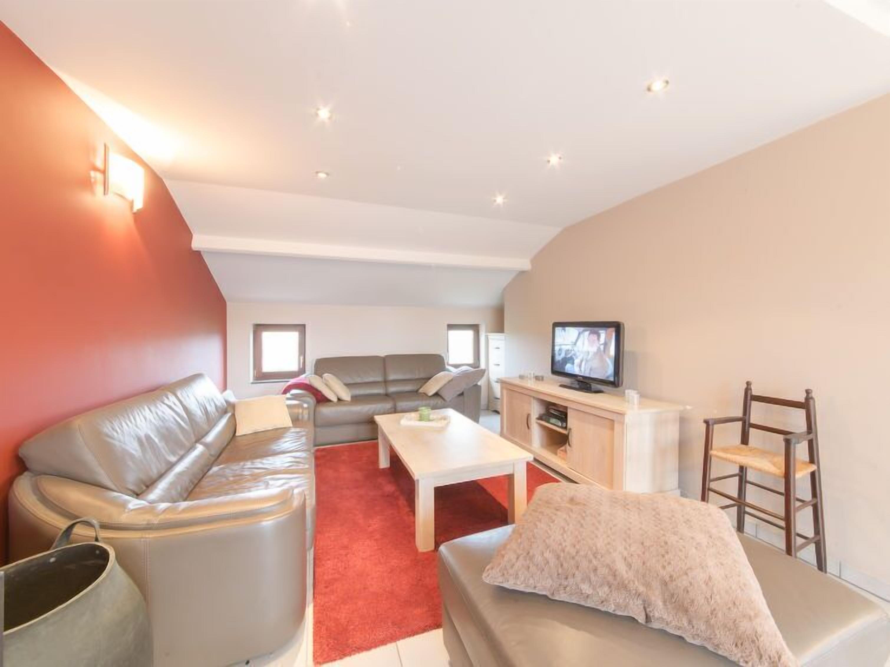 A modern living room with a sofa, a coffee table, and a television.