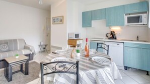 Un espacio habitable compacto con comedor, kitchenette y sofá.