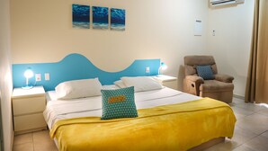 Un dormitorio ordenado con cama, una silla y una mesita de noche.