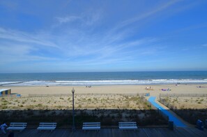 A beach with a wooden boardwalk, benches, and a fence. - Edgewater House - Ocean Front Units With Spectacular Views! (Rehoboth Beach)