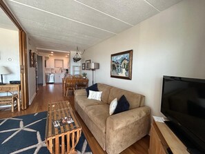 A living room with a sofa, television, and a coffee table.