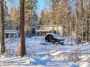 Een besneeerd landschap met een chalet en een overdekt terras.