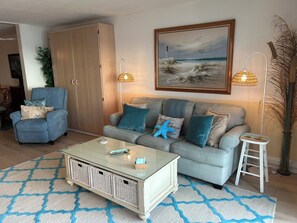 A living room with a sofa, armchairs, a coffee table, and a painting on the wall. - Edgewater House - Ocean Front Units With Spectacular Views! (Rehoboth Beach)