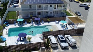 Un immeuble résidentiel doté d’une piscine, de panneaux solaires et d’un espace de stationnement.