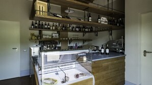 A kitchen with wooden shelves, a glass display case, and various kitchen appliances.