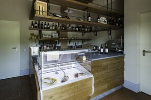Una cocina con estantes de madera, un expositor de vidrio y varios electrodomésticos.