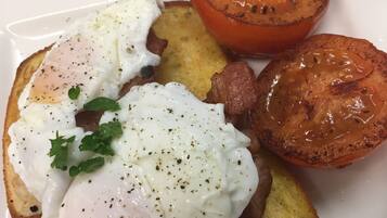 A plate with a poached egg, toast, and roasted tomato.
