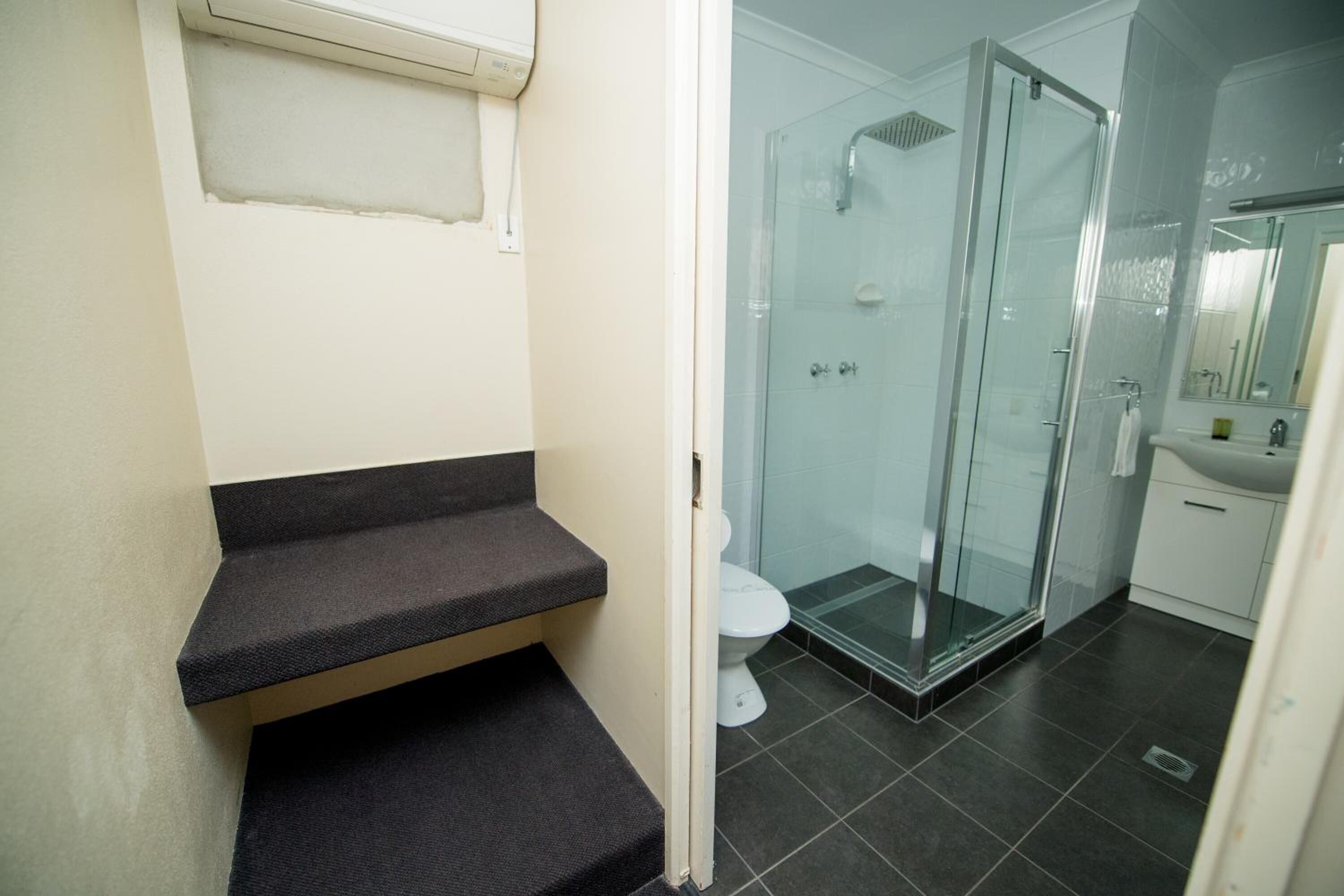 A bathroom with a glass shower enclosure, a white toilet, and a sink.