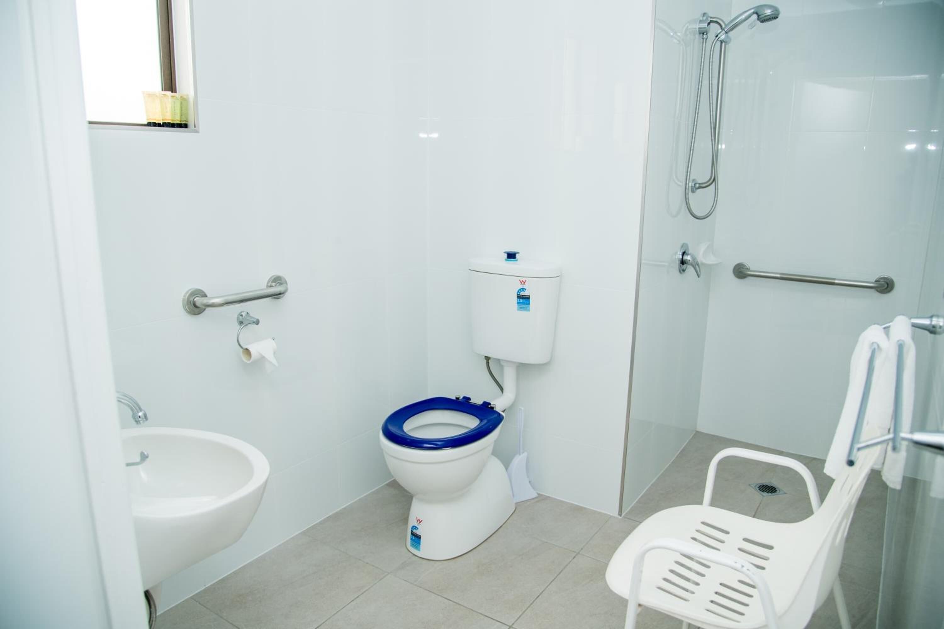 A modern bathroom with a toilet, bidet, and shower.