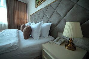 أغطية فراش متميزة وخزنة داخل الغرفة ومكتب ومساحة عمل للكمبيوتر المحمول