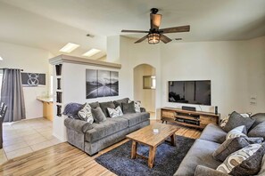 A modern living room with a grey sofa, a wooden coffee table, and a ceiling fan. - Elegant Lake Havasu Getaway w/ Pool - 3 Mi to Lake (Lake Havasu City)