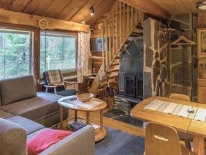 A cozy cabin interior with a stone fireplace, wooden furniture, and a staircase. - Vacation home  by Interhome (Äkäslompolo)