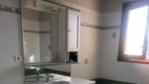 Un baño con inodoro, lavamanos, tocador y bañera.