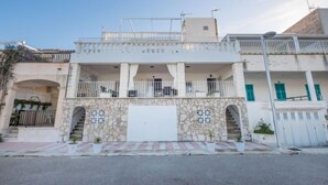 A two-story building with a balcony, a stone facade, and a white garage door. - Voramar 2 by Interhome (Alcúdia)