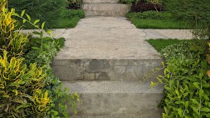 A stone staircase leading up to a building surrounded by lush greenery. - Singgahan Bungalow by ecommerceloka (Penida Island)