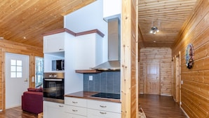Una cocina moderna con armarios blancos, horno empotrado y encimera de madera.