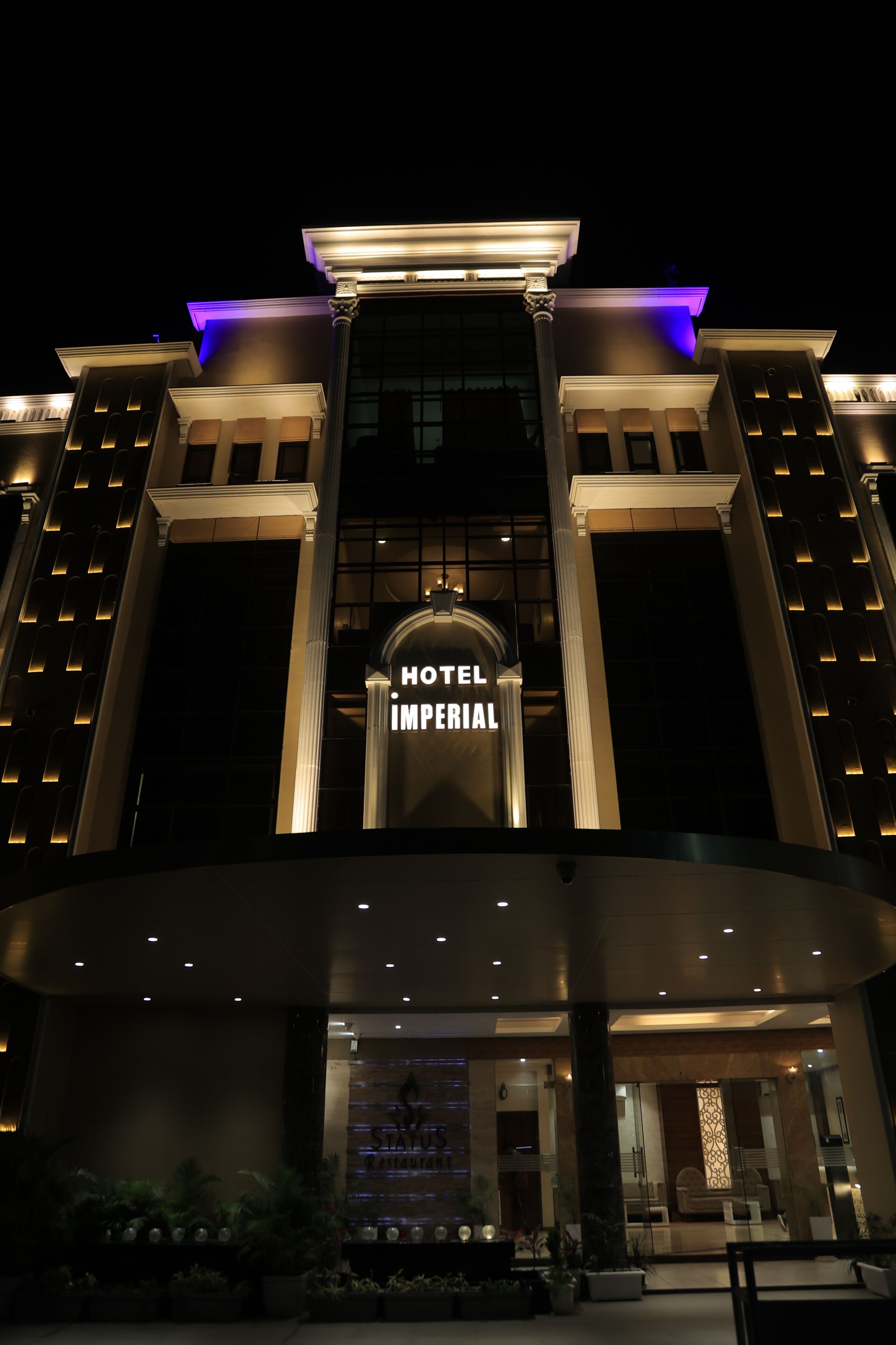 A hotel with a prominent entrance, large columns, and a sign reading 'HOTEL IMPERIAL'.