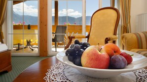 Una mesa de comedor con un frutero en una habitación con vistas a montañas a través de grandes ventanales.