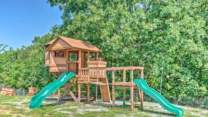 A wooden playground with two slides and a climbing structure. - Kimberly's Hope Clark Apt on Farm w/ Pool Access (Clark)