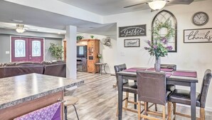 A modern kitchen with a central island, dining area with chairs, and a ceiling fan. - Kimberly's Hope Clark Apt on Farm w/ Pool Access (Clark)