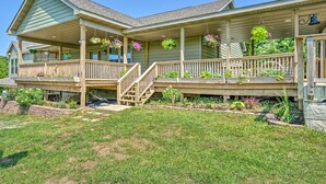 A two-story house with a covered porch, wooden railings, and hanging flower baskets. - Kimberly's Hope Clark Apt on Farm w/ Pool Access (Clark)