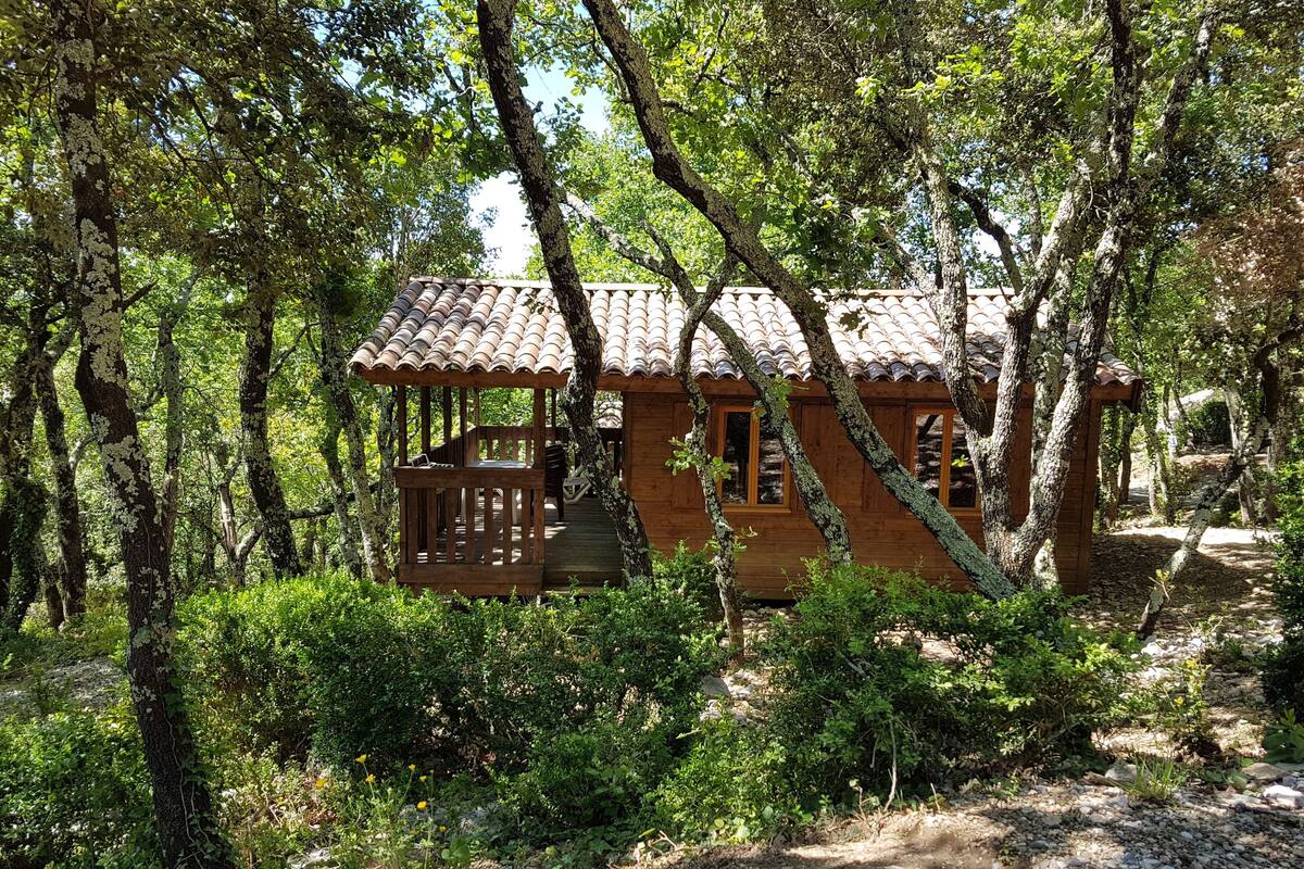 Eine Holzhütte mit Ziegeldach, umgeben von dichtem Wald.