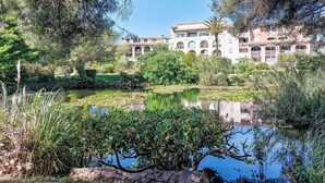 A hotel with a large pond, surrounded by lush greenery and trees. - Les Rivages de Coudoulière by Interhome (Six Fours La Coudoulière)