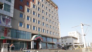 A multi-story hotel with a modern facade, featuring a mix of brick and glass elements. - Debredamo hotel (Addis Ababa)