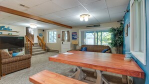 A cozy room with a wooden table and benches, a sofa, and a television. - 2-Level Home w/ Deck: 1/2 Mi to Lake McConaughy! (Lemoyne)
