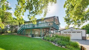 A two-story house with a covered patio, a garage, and a well-maintained lawn. - 2-Level Home w/ Deck: 1/2 Mi to Lake McConaughy! (Lemoyne)