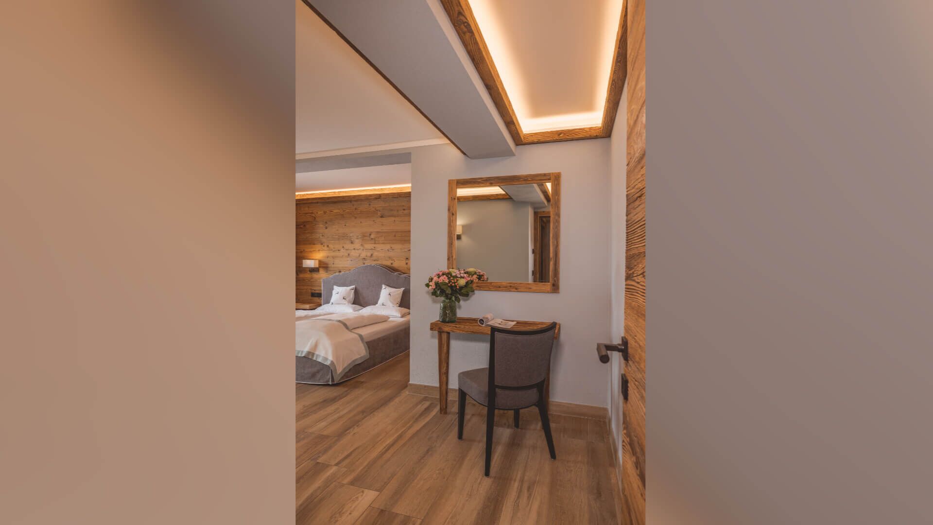 Ein Schlafzimmer mit Bett, Nachttisch, Stuhl und Spiegel.