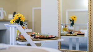 A breakfast table with a variety of food items and a vase of yellow flowers. - B&B Kingsman (Florence)