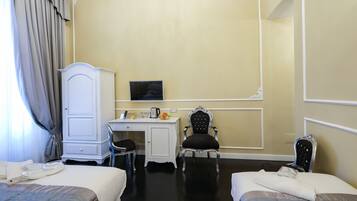 A hotel room with two beds, a desk, a chair, and a television.