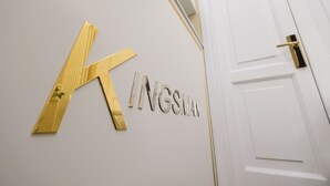 A white door with a gold handle and a gold 'K' sign above it. - B&B Kingsman (Florence)