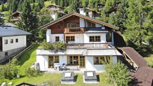 A two-story chalet with a balcony, surrounded by a forested mountain area. - Lena Top 2 by Interhome (Königsleiten)