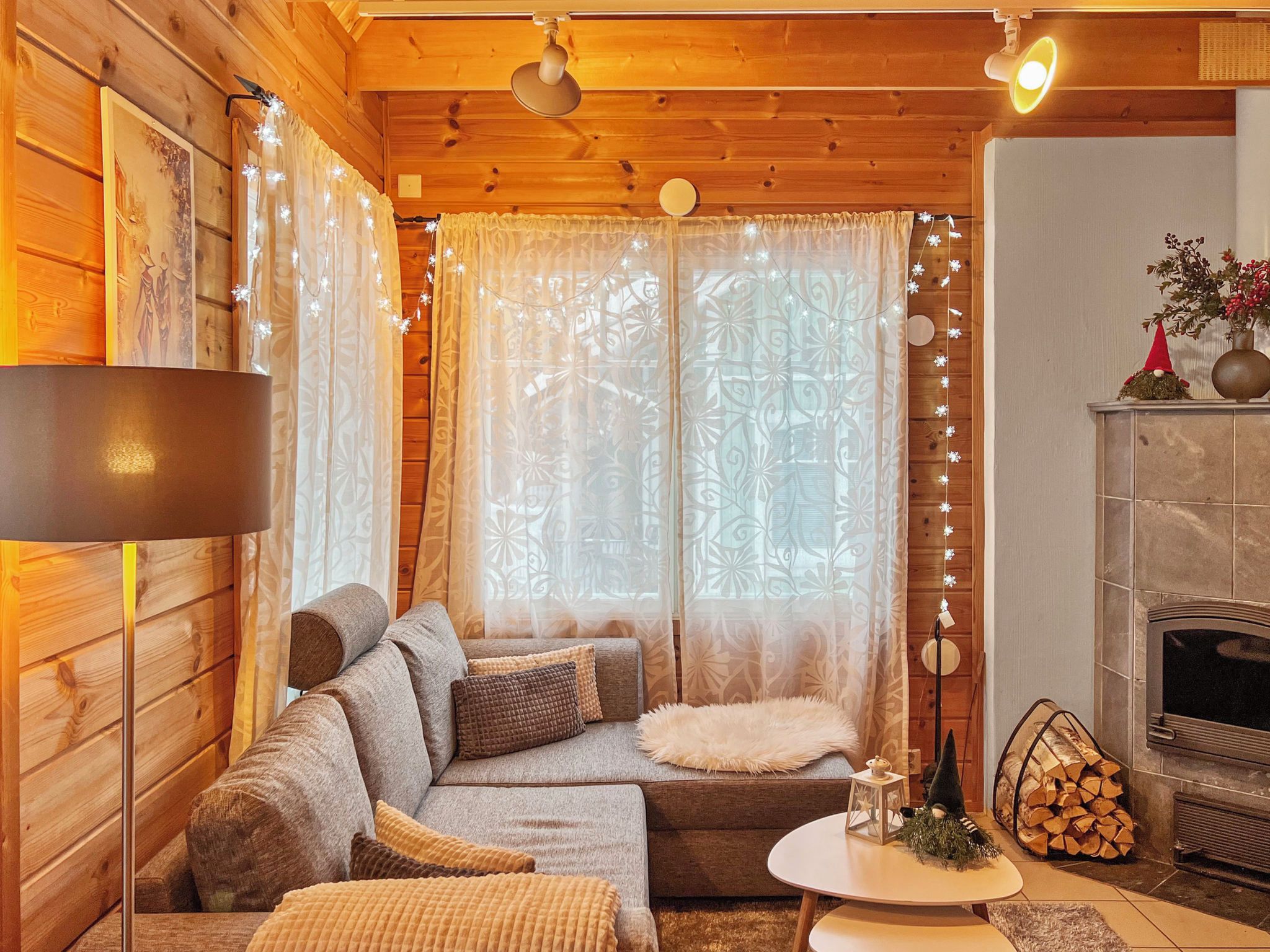 A cozy log cabin interior with a sofa, a small table, and a fireplace.