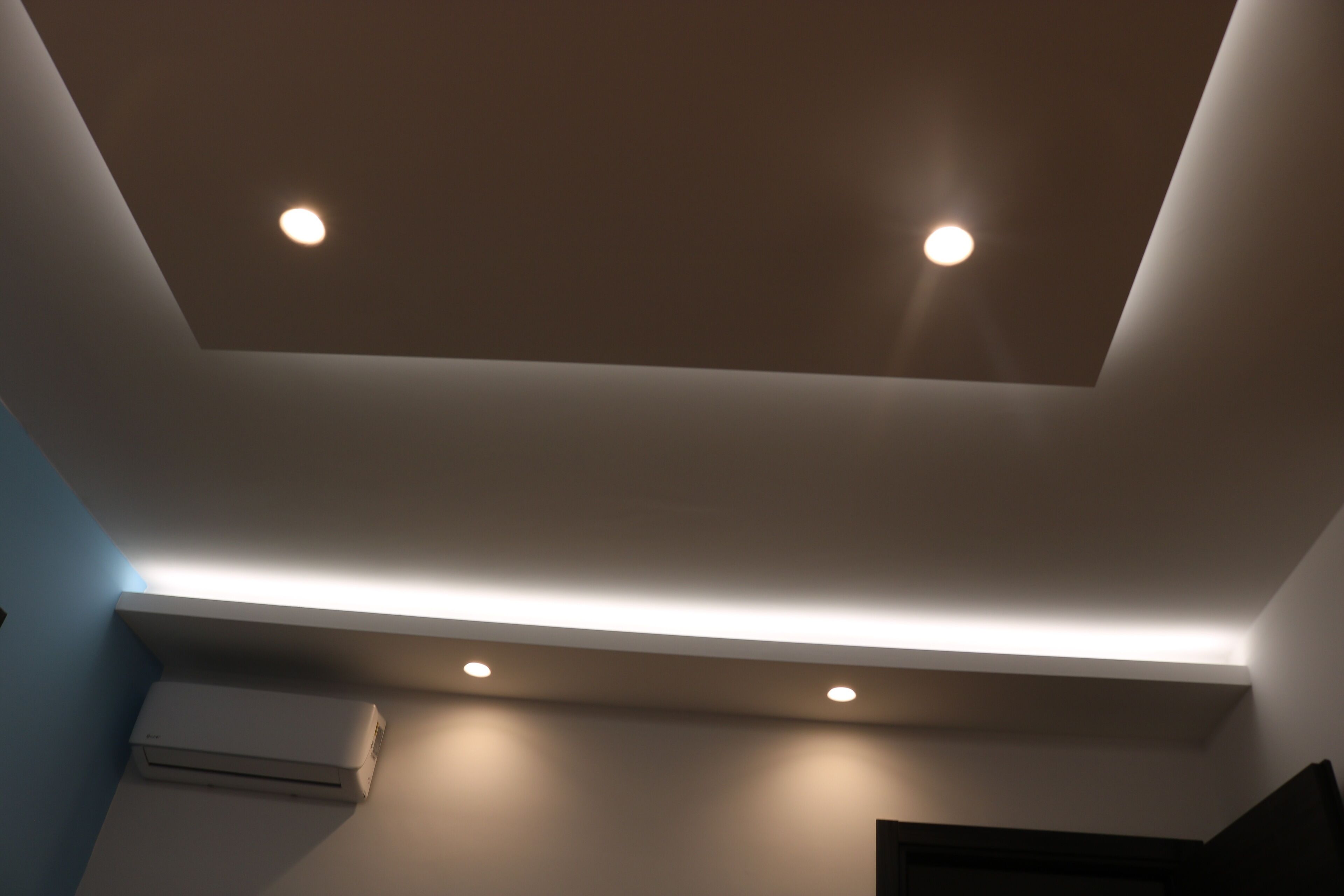 Un soffitto con luci a incasso e un lucernario.