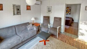 A modern living room with a grey sofa, two armchairs, a coffee table, and a hanging light fixture. - Huitsin nevada by Interhome (Muonio)