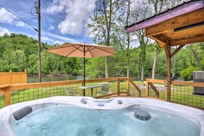 A hot tub with a wooden deck, surrounded by a wooden fence, overlooking a river and lush greenery. - Private Hot Tub: Tuckasegee River Couple's Escape (Bryson City)