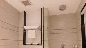 Ein modernes Badezimmer mit einer gläsernen Duschkabine, Toilette und einem Waschbecken mit Marmorplatte.