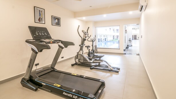 Ein Fitnessraum mit Laufbändern, Ergometer und einem Deckenventilator.