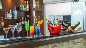 A bar area with a variety of drinks and bottles, a Red Bull logo, and a wooden bar counter.