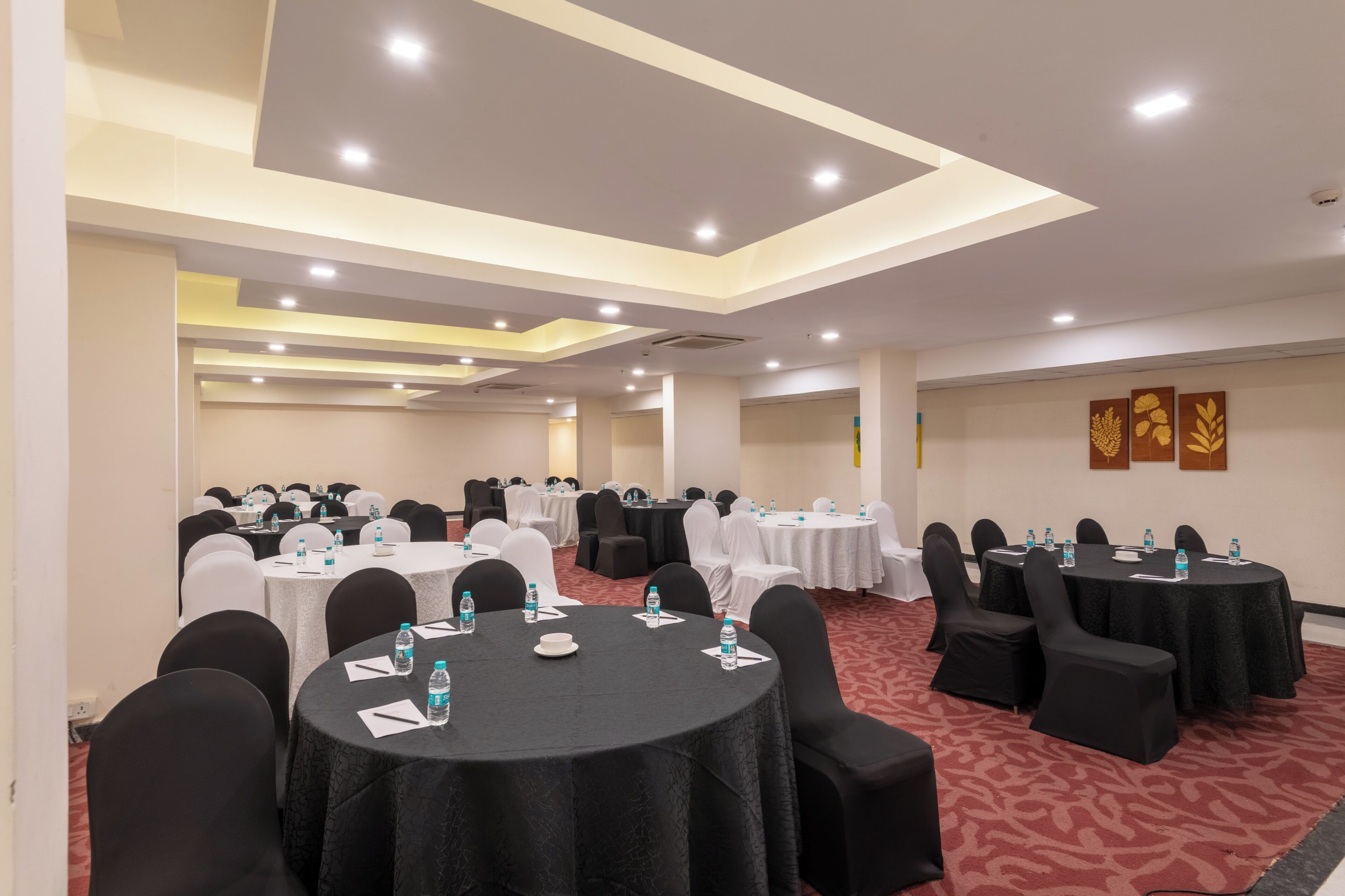A conference room with round tables, chairs, and water bottles.