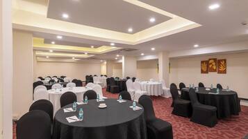 A conference room with round tables, chairs, and water bottles.