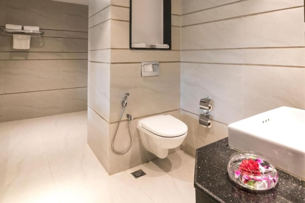 A modern bathroom with a toilet, shower, and sink.