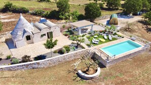 Une villa dotée d’une piscine, d’un espace extérieur aménagé et d’un chemin en pierre.