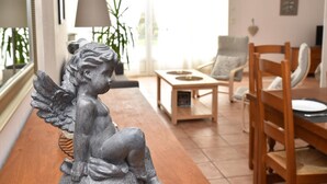 Una sala de estar con una estatua, una mesa de comedor, sillas y una lámpara.